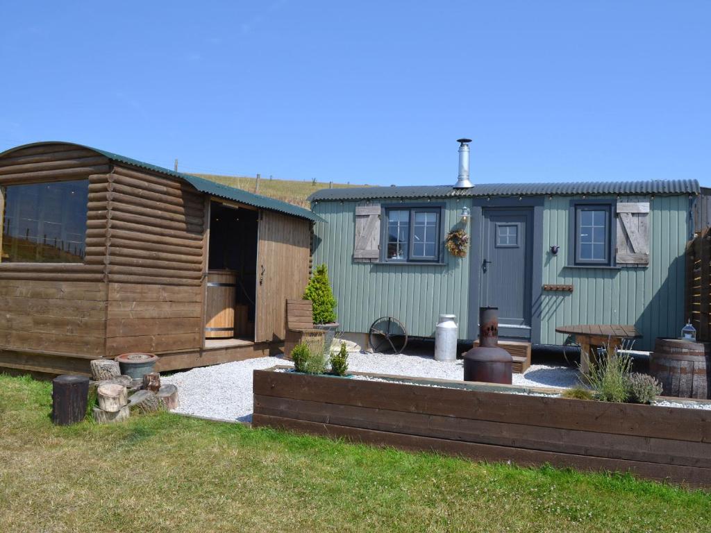 a backyard of a house with a wooden shed at Heather Hut at Copy House Hideaway in Barnoldswick