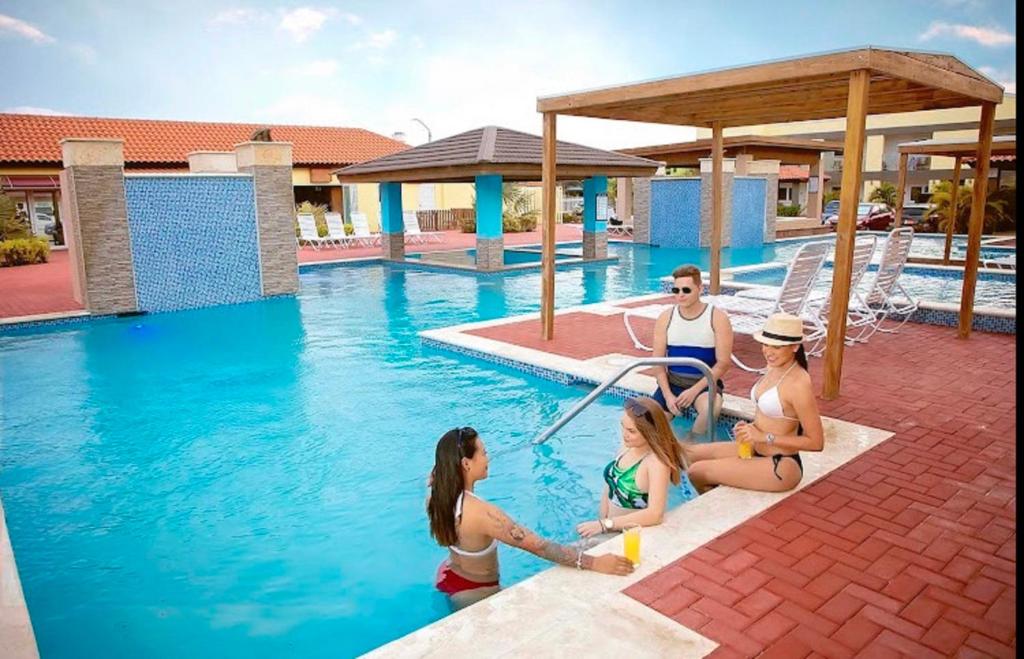 un grupo de mujeres sentadas en una piscina en Pearl Aruba en Palm-Eagle Beach