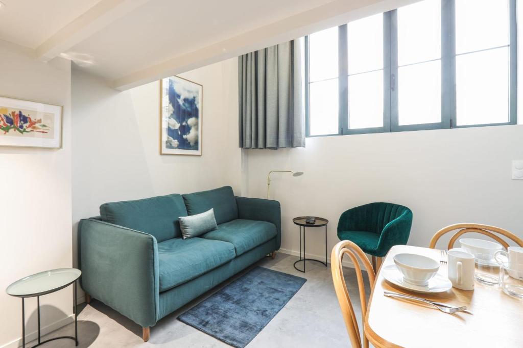 a living room with a blue couch and a table at Beautiful and bright duplex nearby Alesia - Paris - Welkeys in Paris
