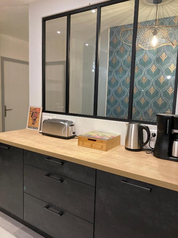 a counter top with a toaster and a window at Gîte "le haut des Poujades" in Reilhaguet