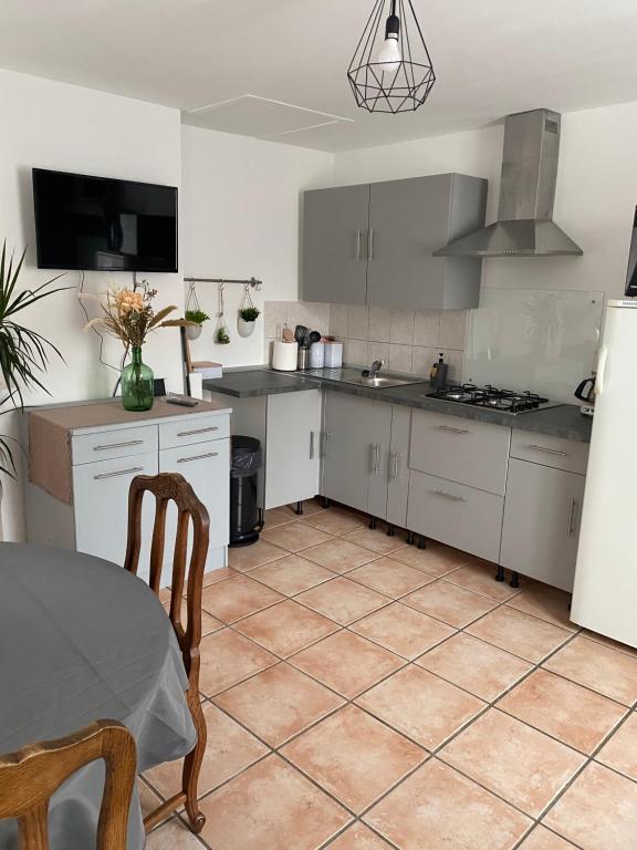 的住宿－Maison calme et confortable，厨房配有白色橱柜和一张桌子