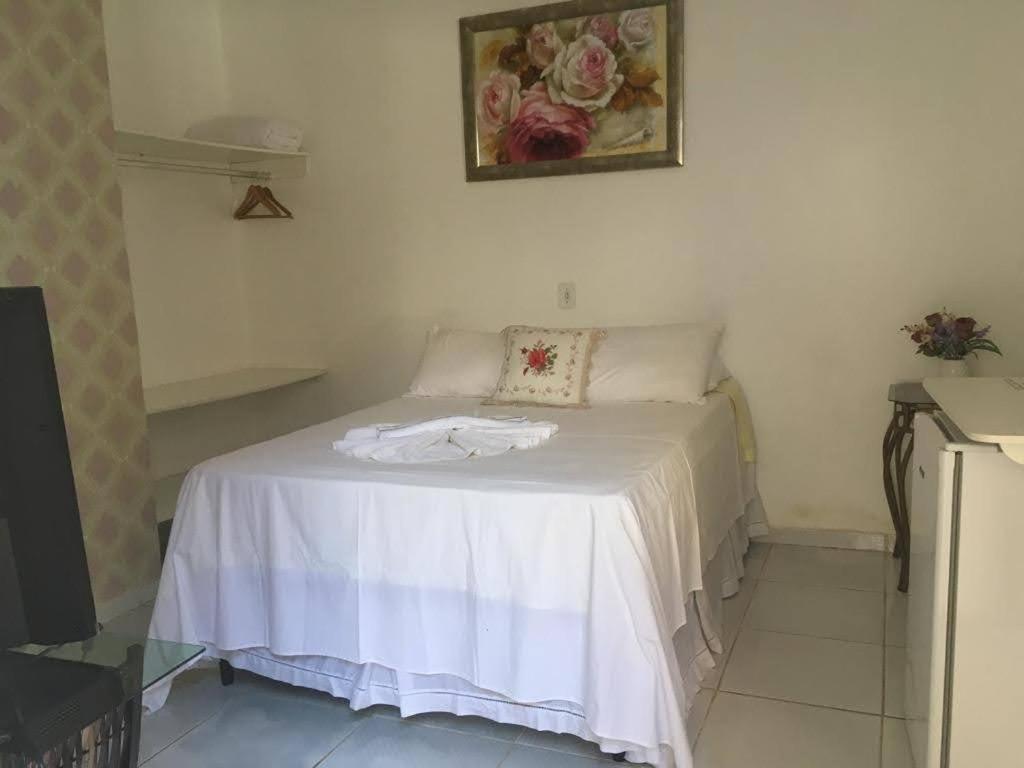 a white bed in a room with a picture on the wall at Chalé Marinas in Barreirinhas