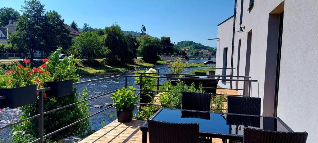 a balcony with a table and chairs and a river at Rezidence Valcha in Sušice