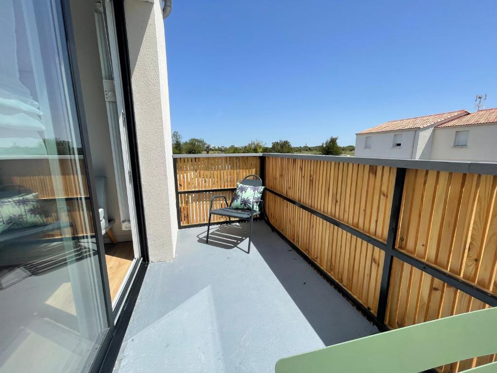 a balcony with a chair and a fence at Superbe appartement La Rochelle in La Rochelle