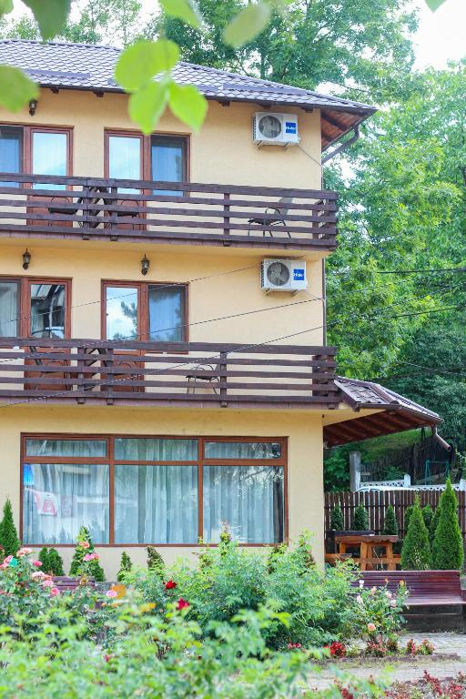 a yellow house with windows and balconies on it at Casa Teju in Slănic
