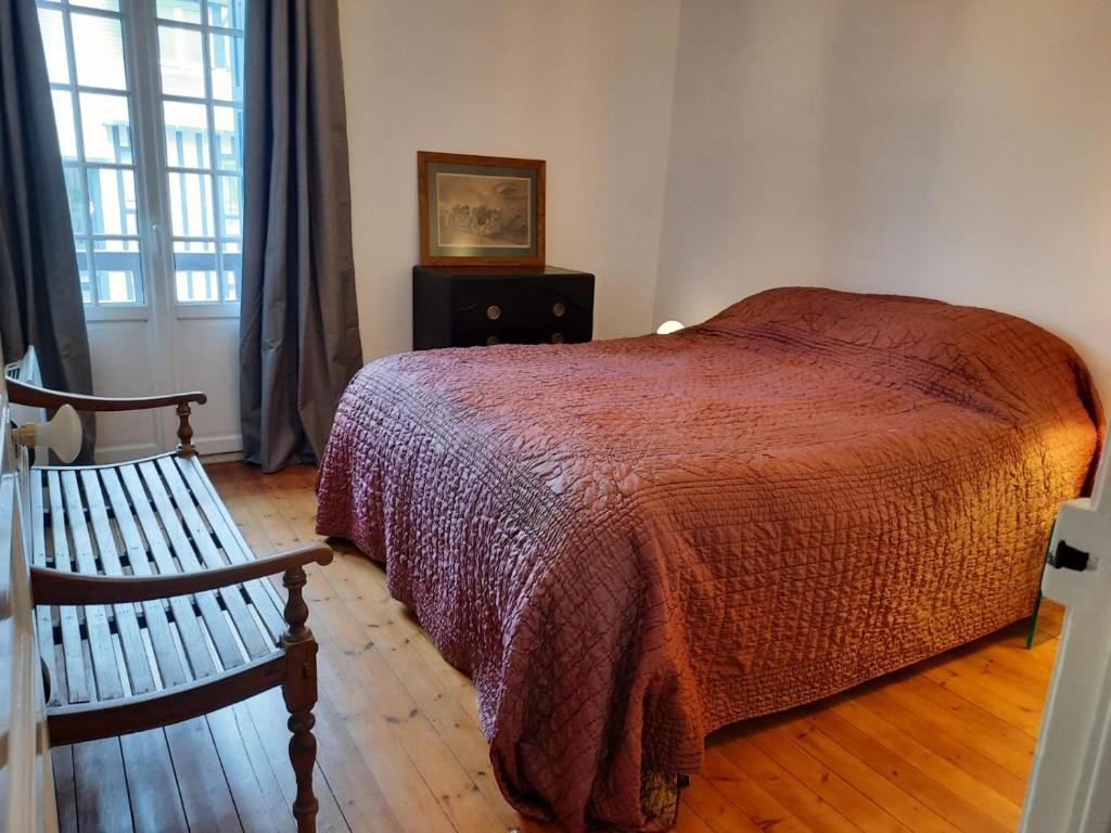 una camera con letto, panca e finestra di THE DUKE a Deauville