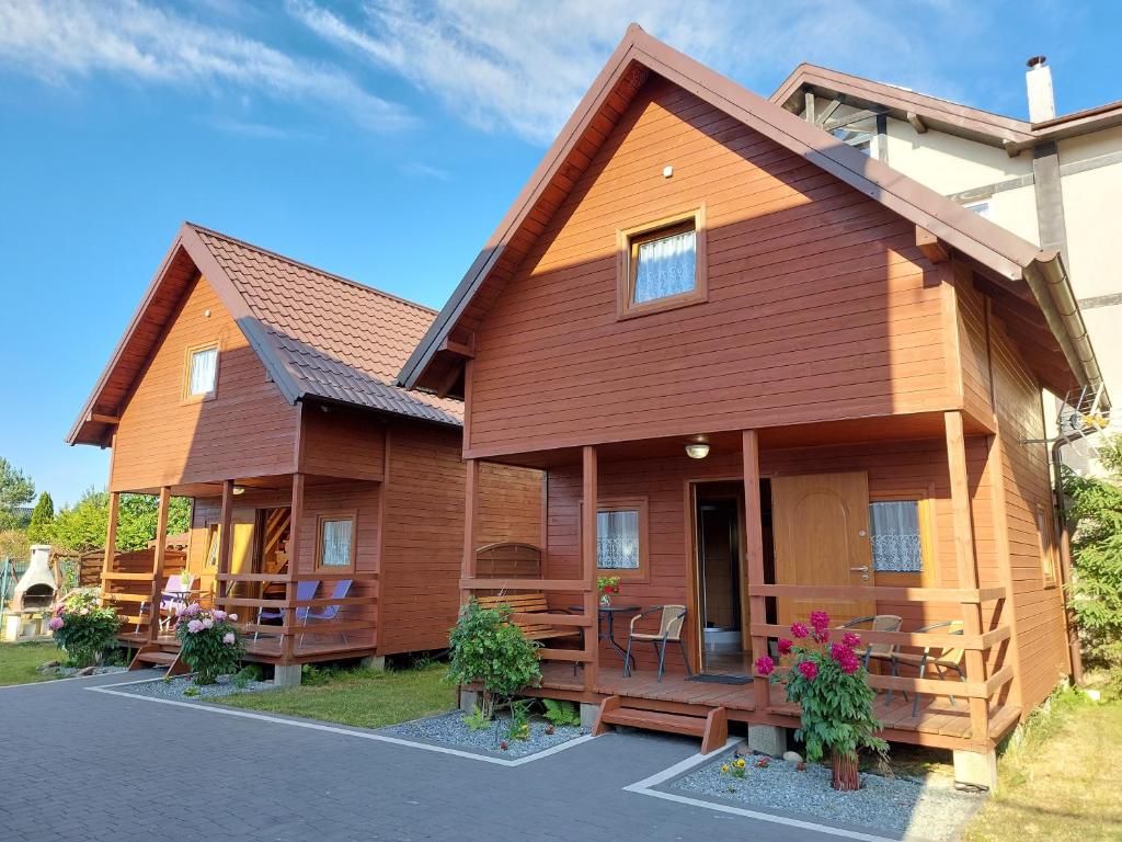 a large wooden house with a porch at Domki Agatka in Władysławowo