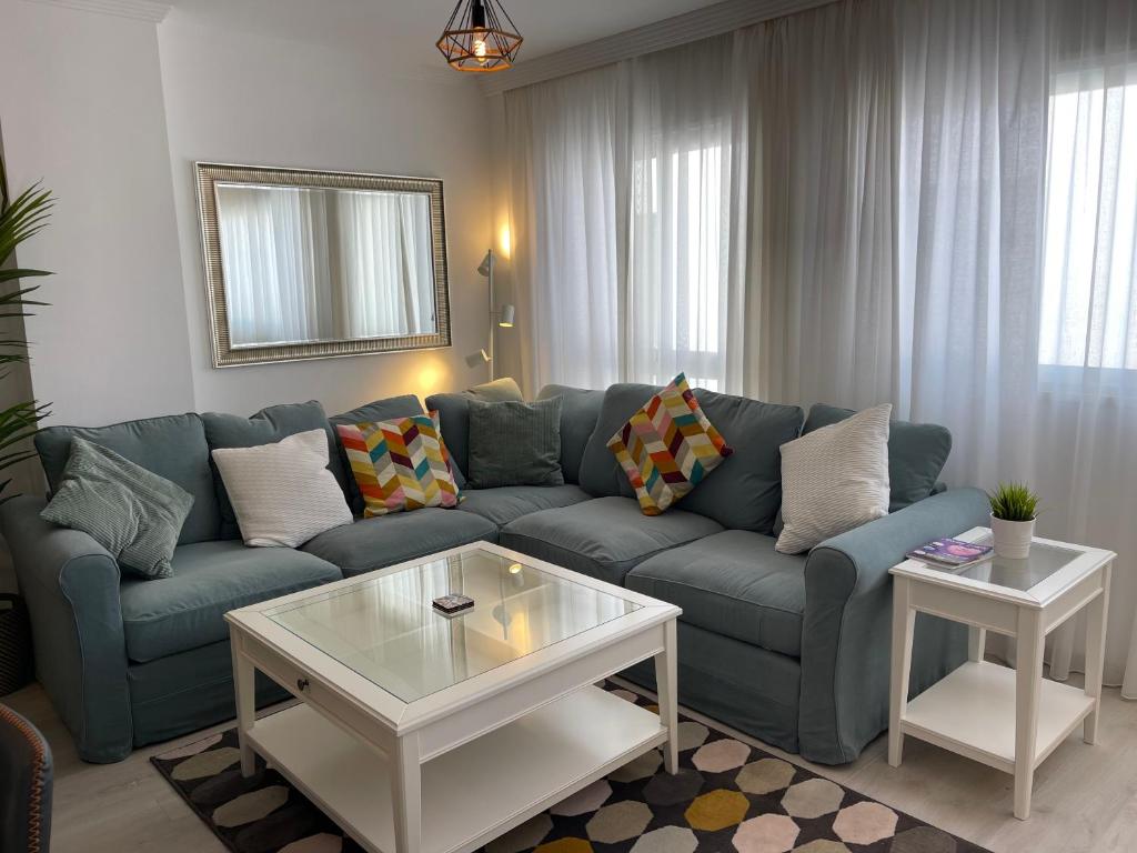 a living room with a blue couch and a table at La Cala Holiday Retreat in La Cala de Mijas