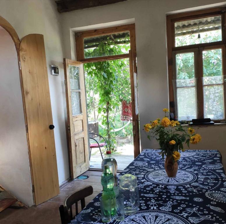 una stanza con un tavolo e un vaso di fiori di Mzia's Garden a Kʼvakhvreli