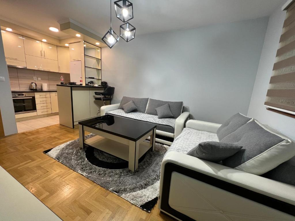 uma sala de estar com um sofá e uma mesa em Apartment stan na dan Hilandarska em Lukavica