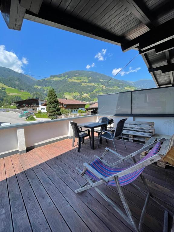 a patio with a table and chairs on a deck at Zack's Mountain Top in Schwendau