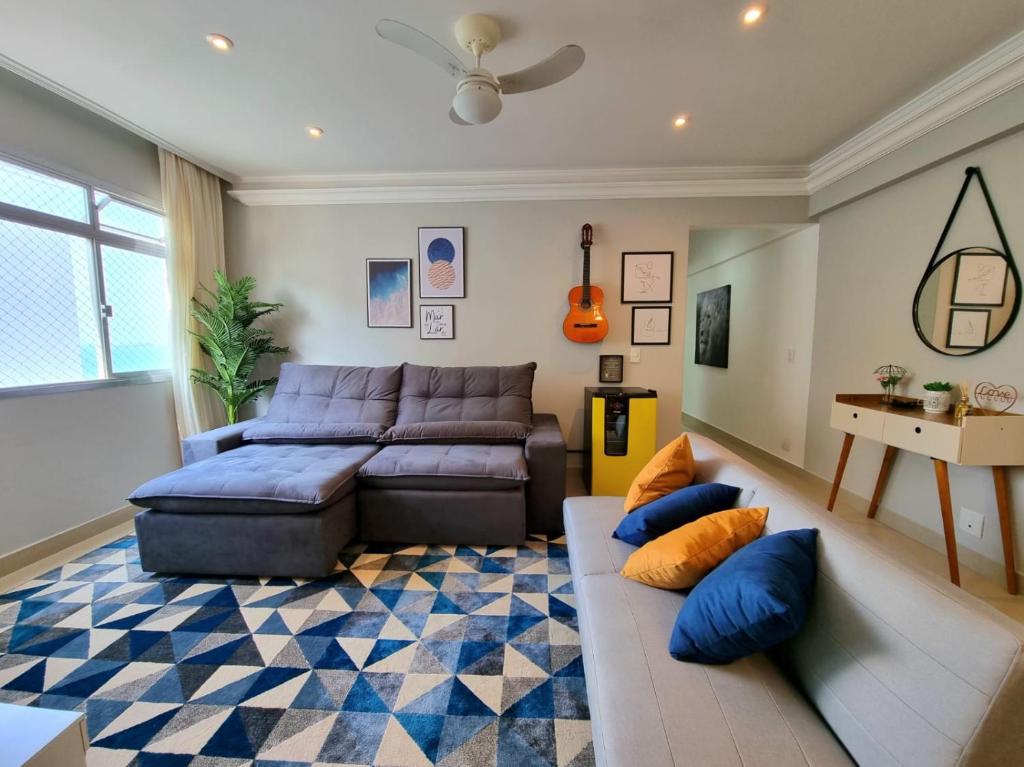 a living room with a couch and a table at Apartamento moderno e aconchegante. Pé na areia!!! in Guarujá