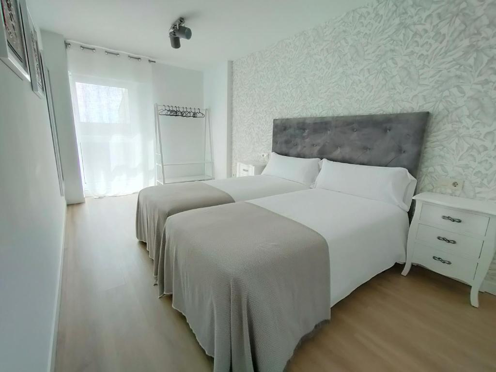 A bed or beds in a room at Second Home Arzúa apartamentos