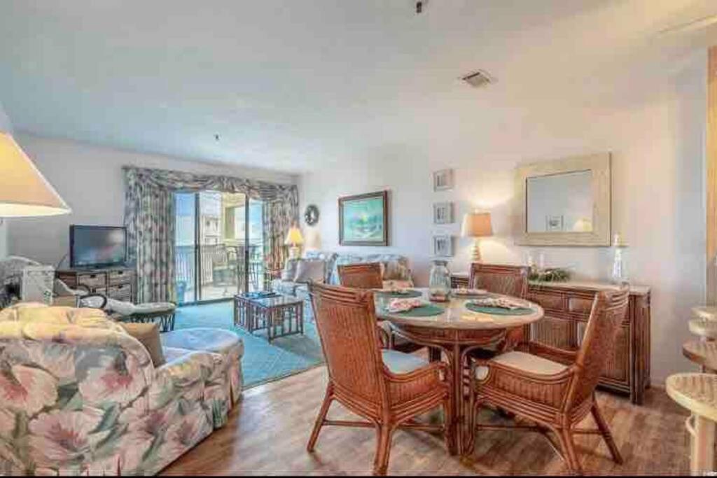 a living room with a table and a couch at Lovely 2-bedroom condo with pool in Myrtle Beach