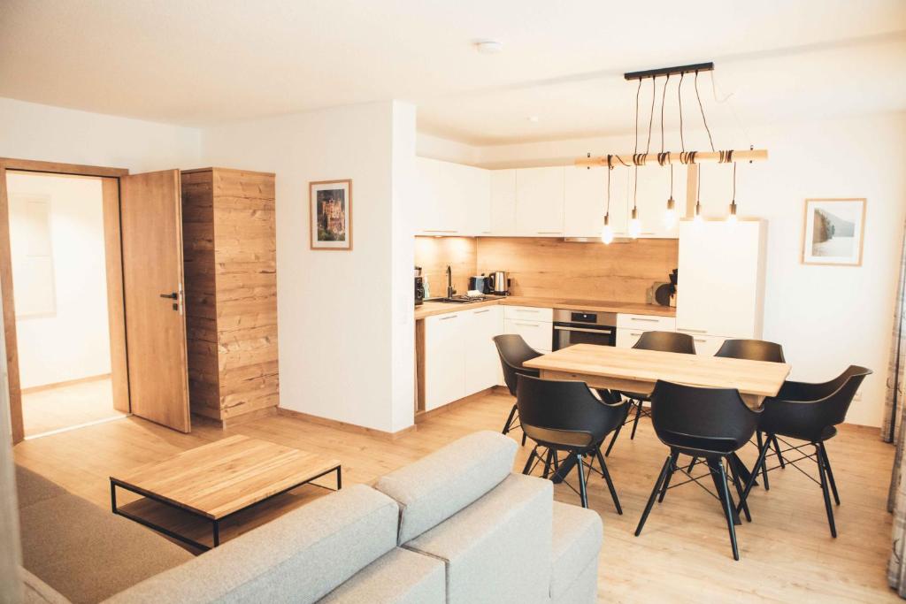 a living room and kitchen with a table and chairs at Haus Schwangau in Schwangau