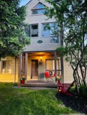 a house with a front door and a yard with grass at perfect 'lil condo in Mont-Tremblant