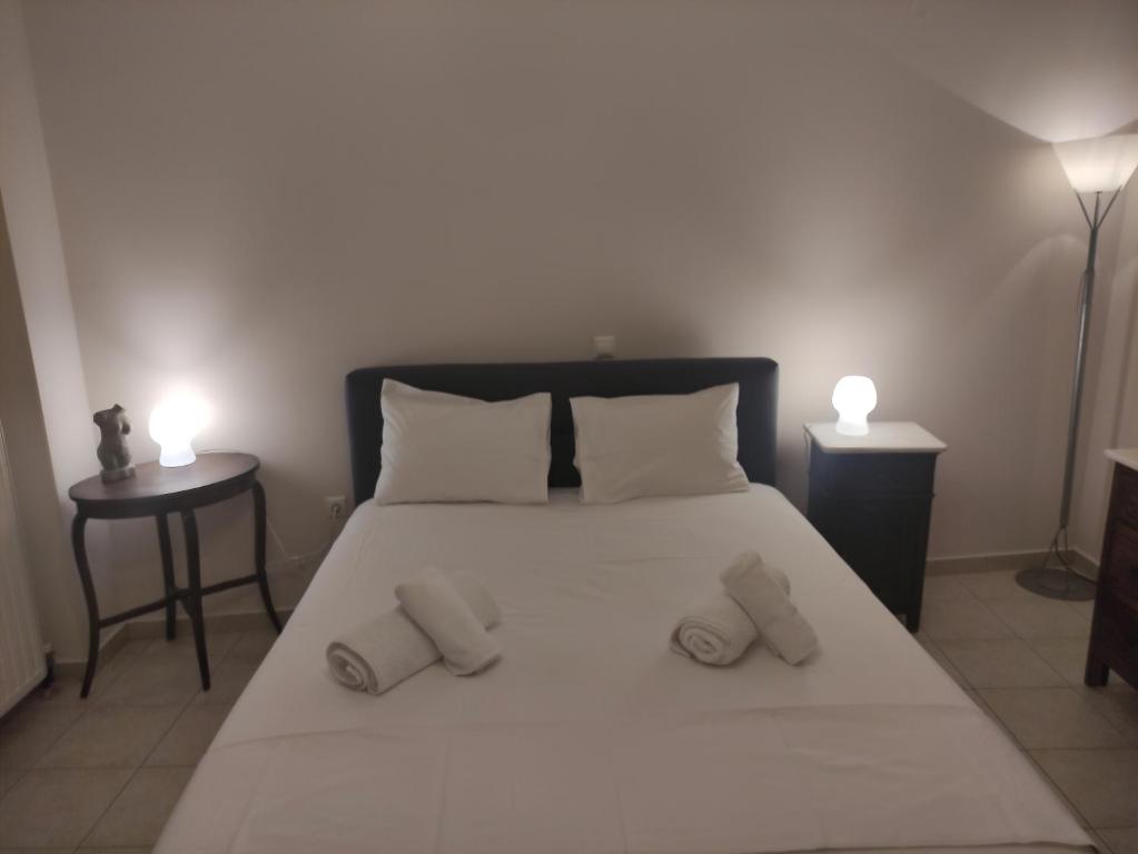 um quarto com uma grande cama branca e 2 almofadas em C' est la vie em Nafplio