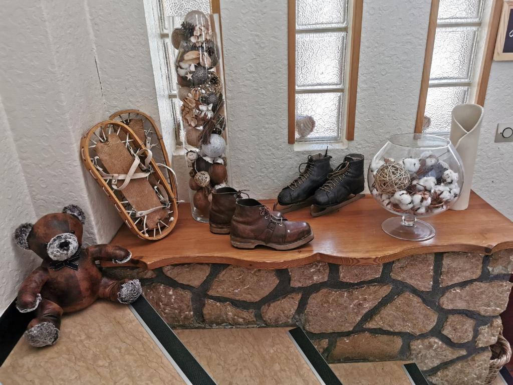 a shelf with a bunch of shoes and a mirror at Hôtel Au Feu De Bois bar à vin le 1605 in Autrans