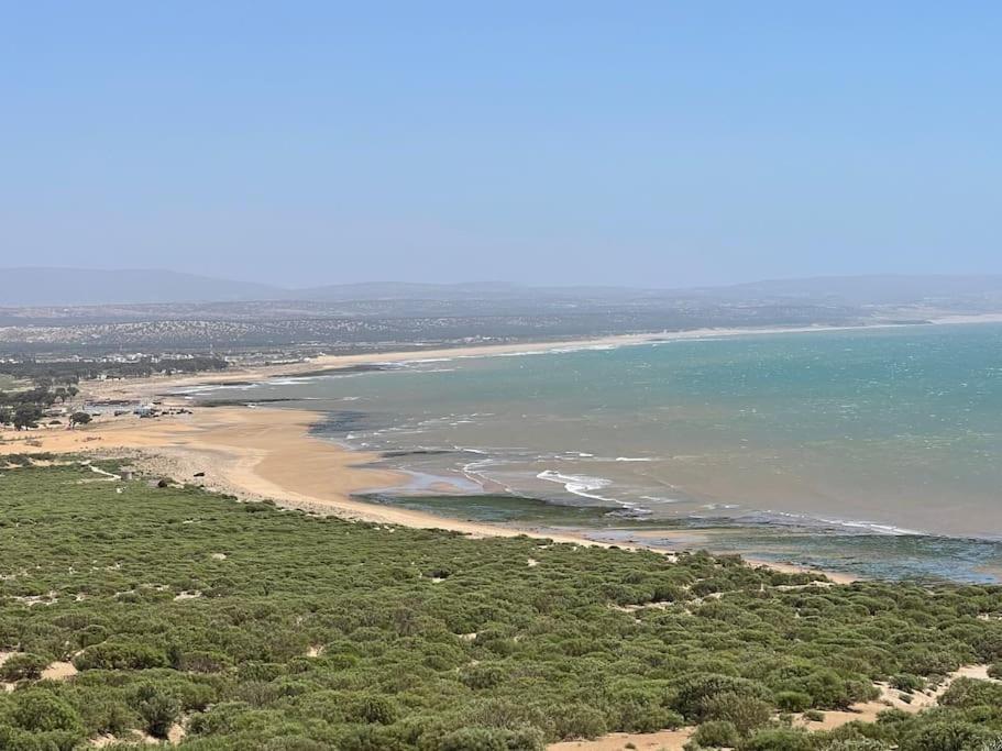 una vista aerea su una spiaggia e sull'oceano di Dar Nouha : un appartement sur l'océan a Wassane