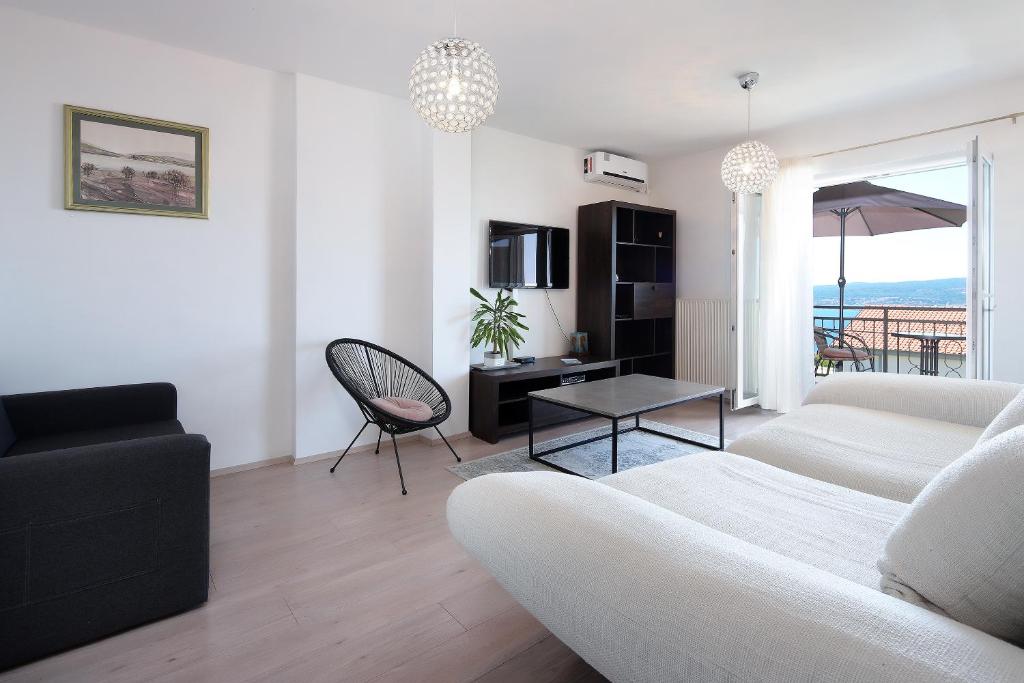 a living room with a couch and a table at Sunset Apartments in Crikvenica