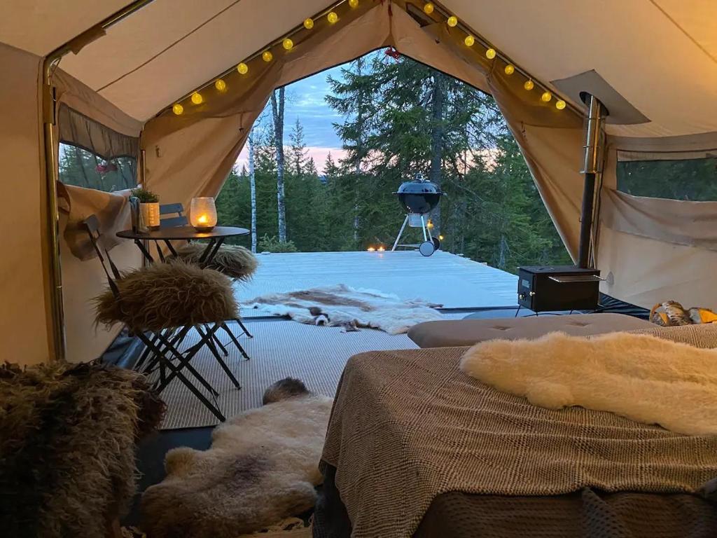 a tent with a table and a grill in it at Glamping Tent with amazing view in the forest in Torsby