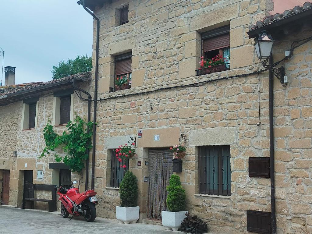 a red motorcycle parked in front of a stone building at Casa Bodega Vacacional in Sajazarra