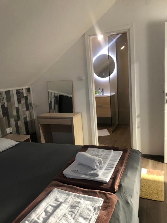 Zimmer mit einem Bett, einem Spiegel und einem Tisch in der Unterkunft MyHome2 in Subotica