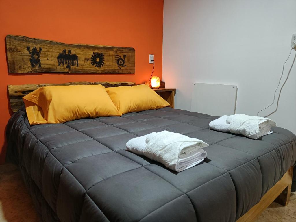 Una cama con dos almohadas encima en una habitación. en Rayo Solar Depto Rama Caída, en San Rafael