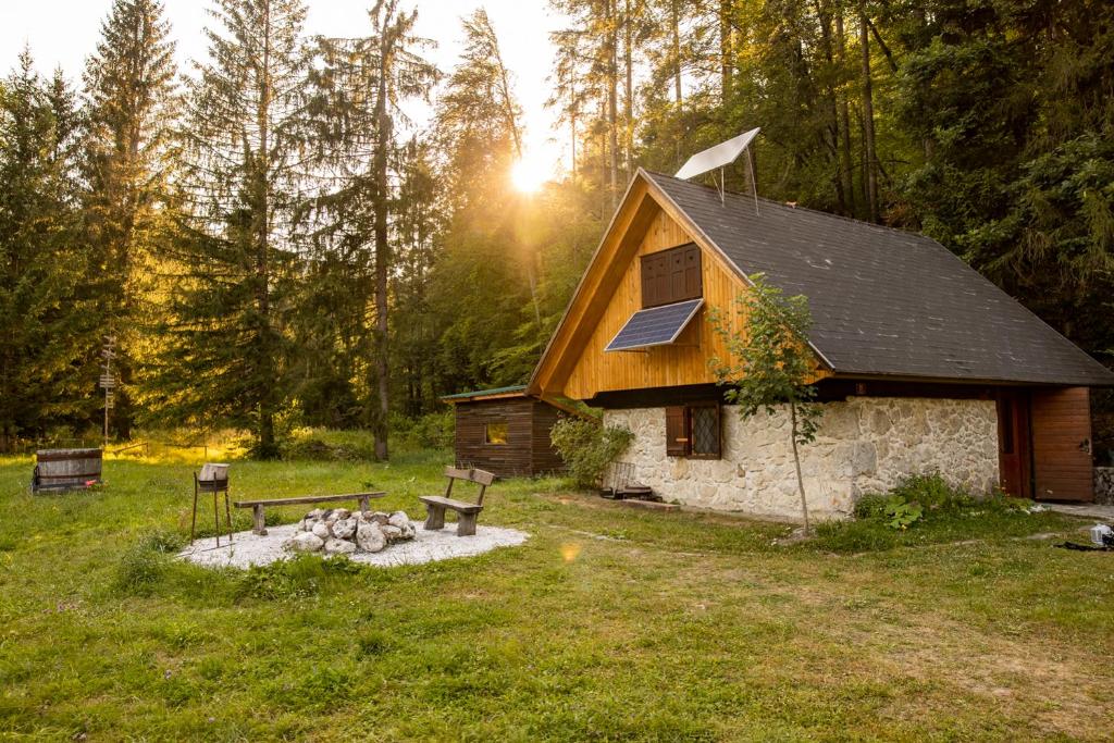 a cabin with a fire pit and benches in front of it at Marko's eco cabin in Bled
