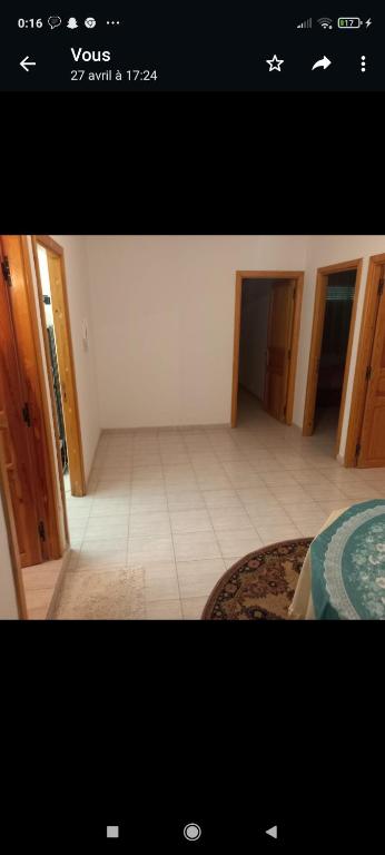 a view of a room with a bed and a room with a tiled floor at Appartement in Taza