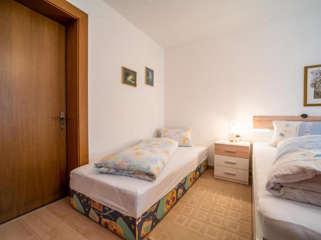 a bedroom with two twin beds and a wooden door at Apartment Claudia in Vandans