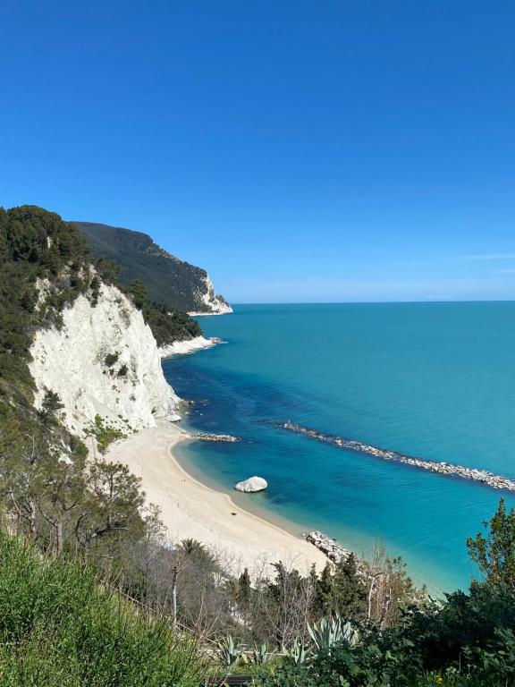 einen Strand an der Seite einer Klippe in der Unterkunft Appartamento esclusivo nella piazza di Numana in Numana