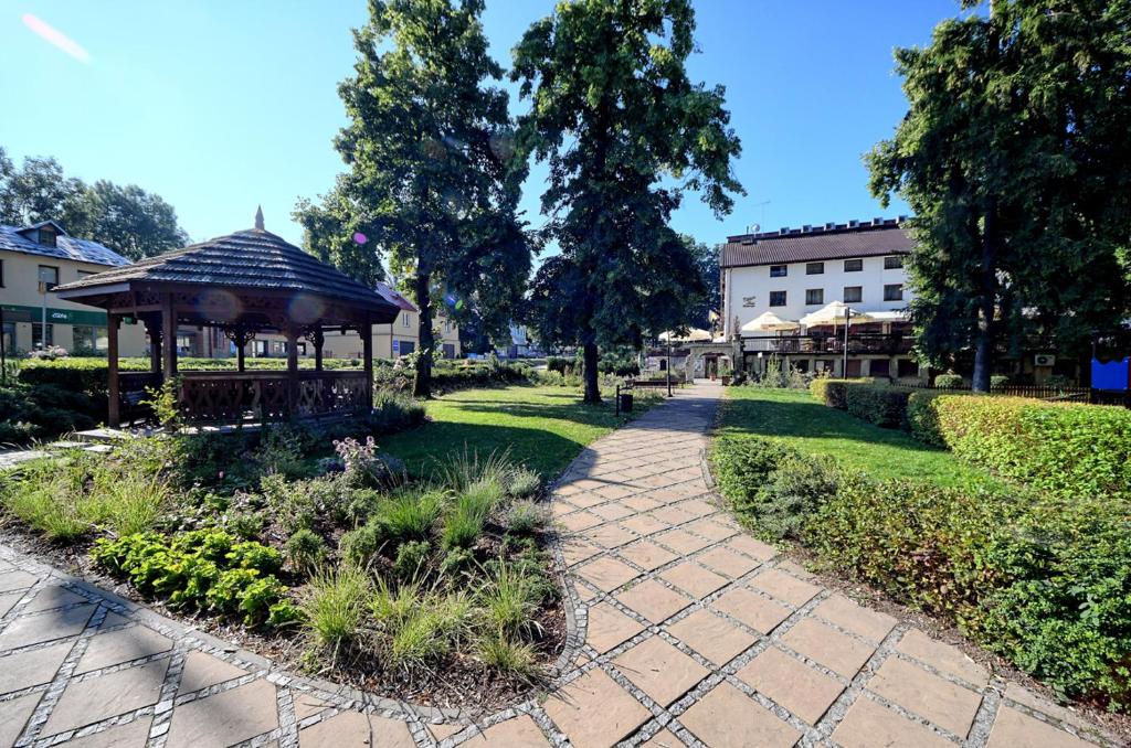 un jardín con cenador en un parque en Hotel Przepióreczka, en Nałęczów