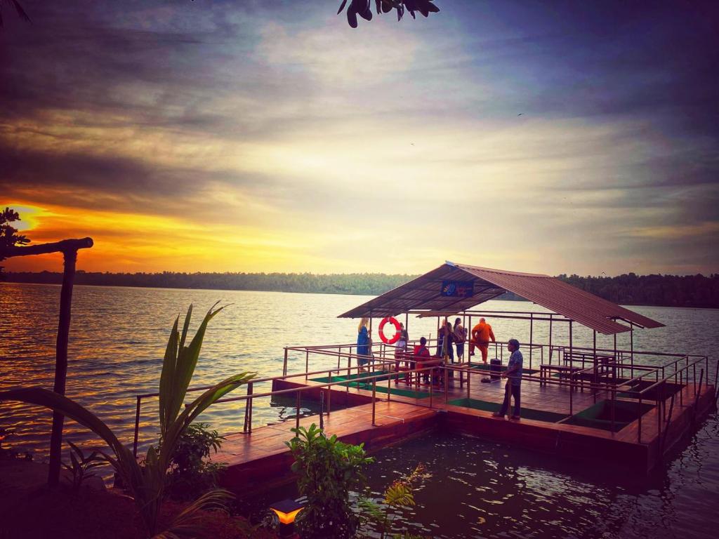 Ein Dock auf einem See, auf dem Leute stehen. in der Unterkunft Vishram Village in Varkala