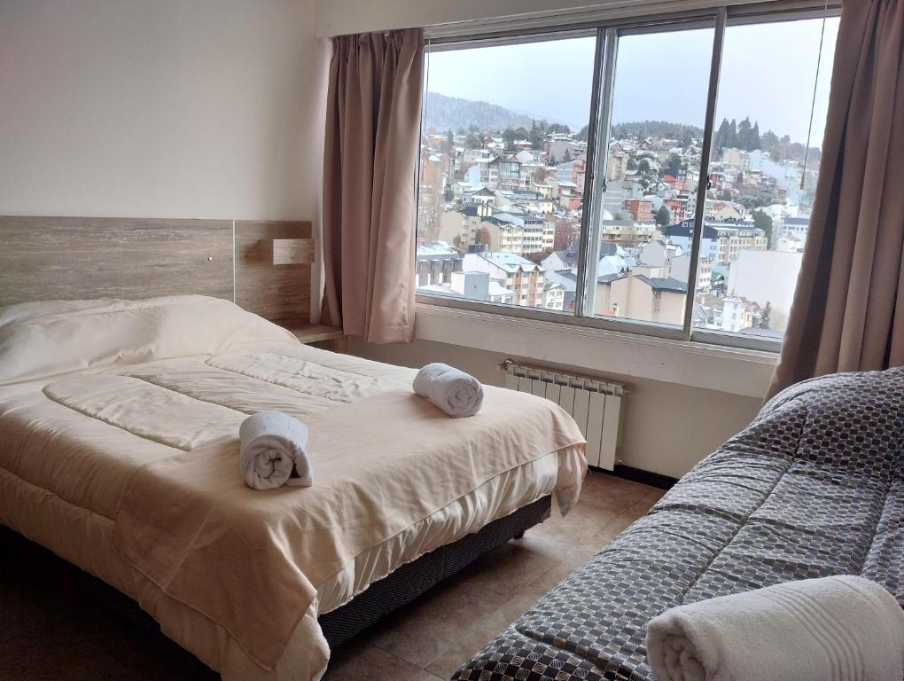 a bedroom with two beds and a large window at Mountain Center in San Carlos de Bariloche