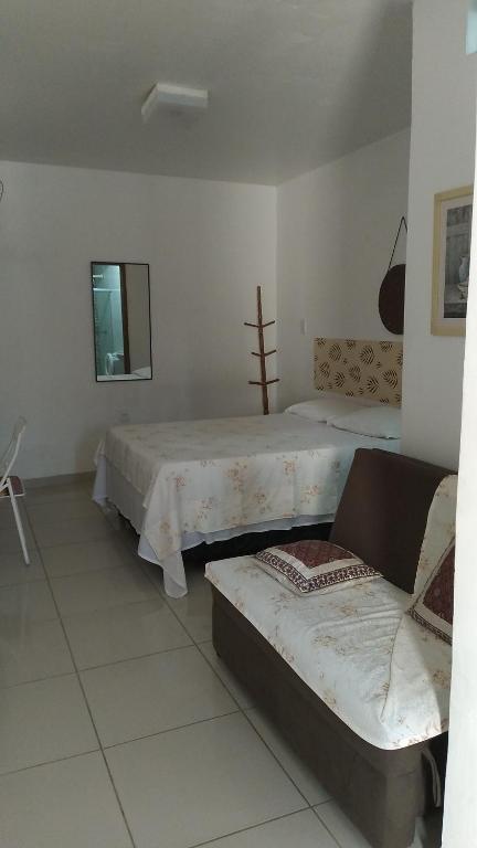 um quarto com duas camas e um sofá em Hospedaria Ilhéus 01 em Ilhéus