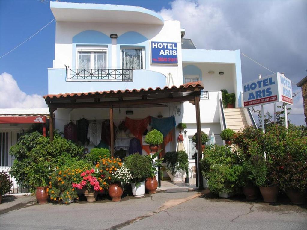 a store with potted plants in front of a building at Aris Rooms in Anogeia