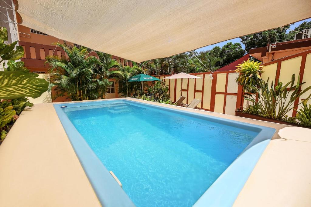 a swimming pool on a patio with an umbrella at Casa Saab in Playa del Carmen