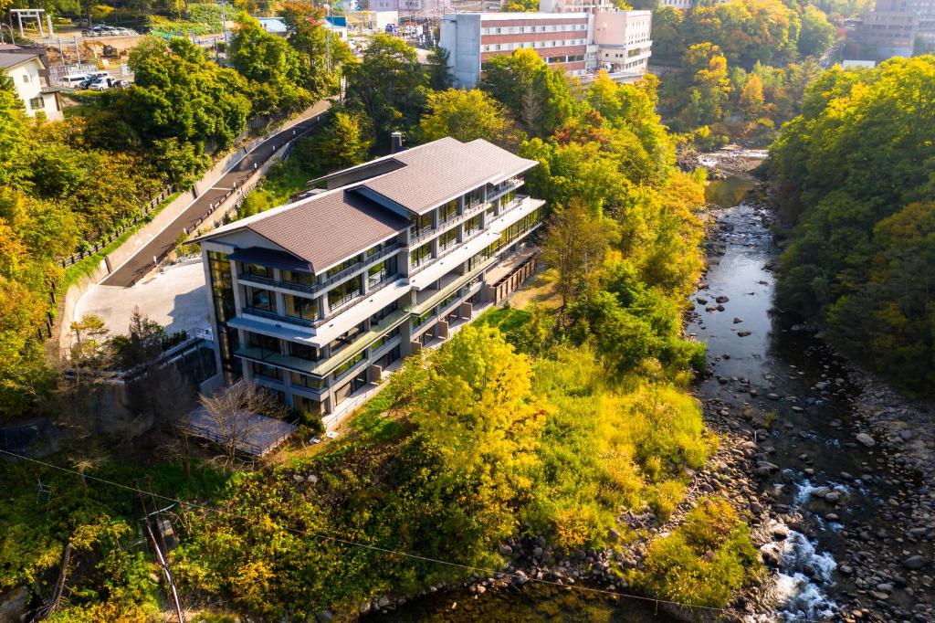 an aerial view of a building next to a river at Chalet Ivy Jozankei in Jozankei