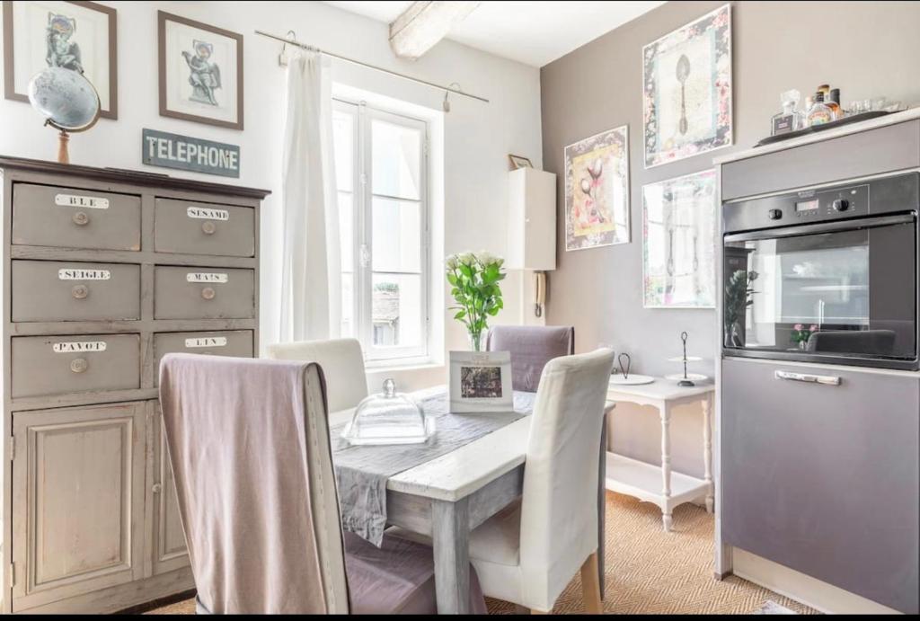 a kitchen with a table and a dining room at Douceur sur la Sorgue in LʼIsle-sur-la-Sorgue