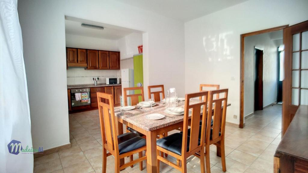 een keuken en eetkamer met een tafel en stoelen bij Casa do Romaninho in Porto da Cruz