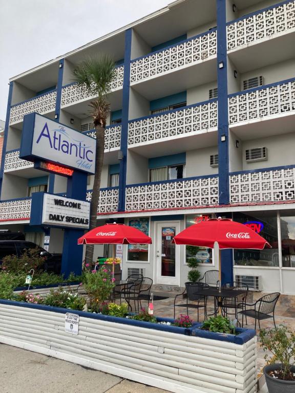 a hotel with tables and umbrellas in front of it at The Atlantic in Myrtle Beach