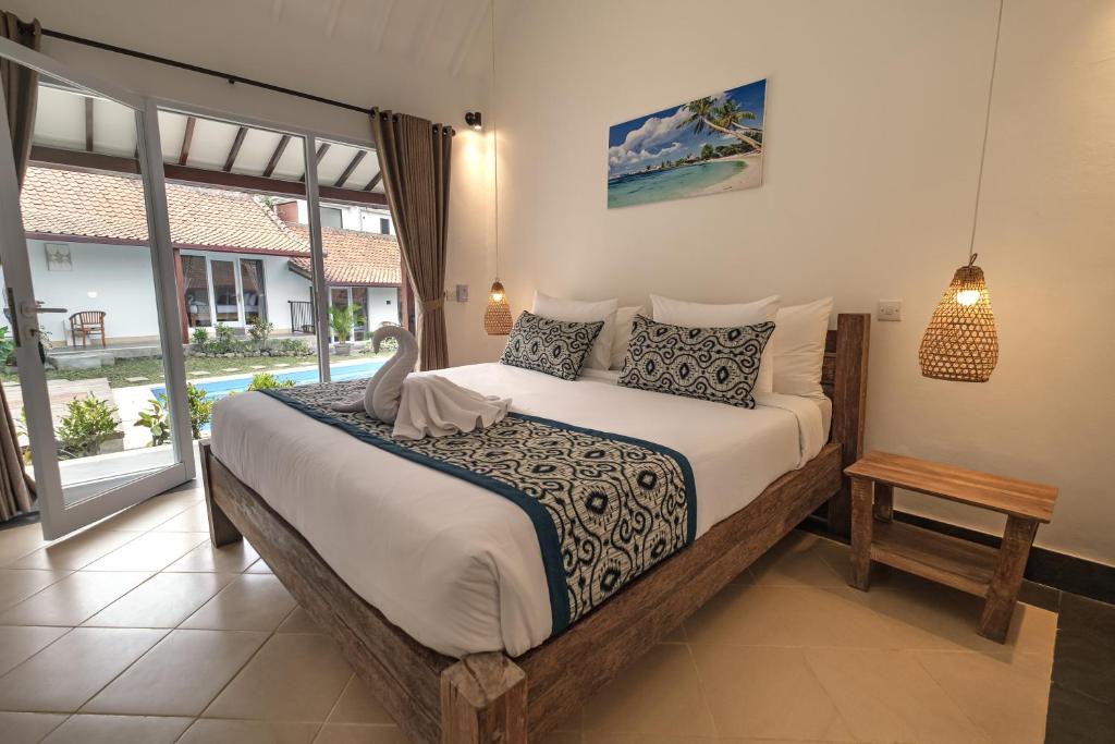sypialnia z dużym łóżkiem i dużym oknem w obiekcie Nami Surf Stay w mieście Canggu