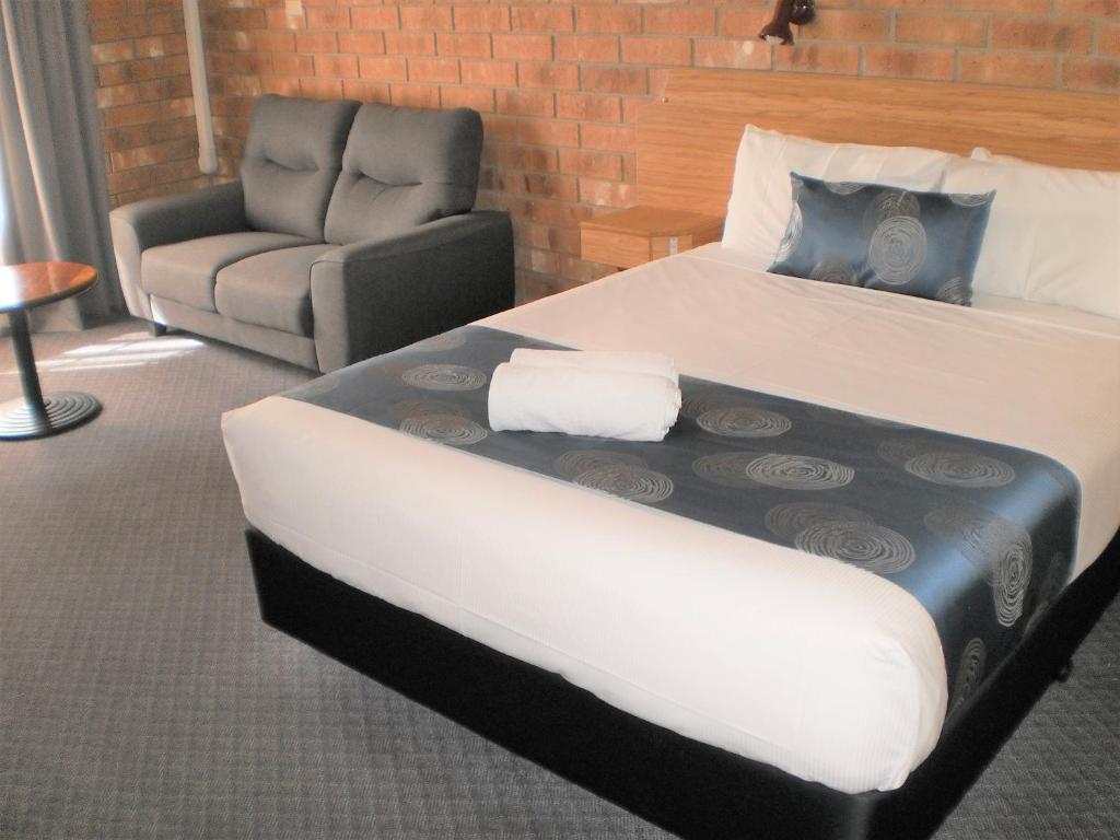 ein Hotelzimmer mit einem Bett und einem Stuhl in der Unterkunft Motel Goolwa in Goolwa