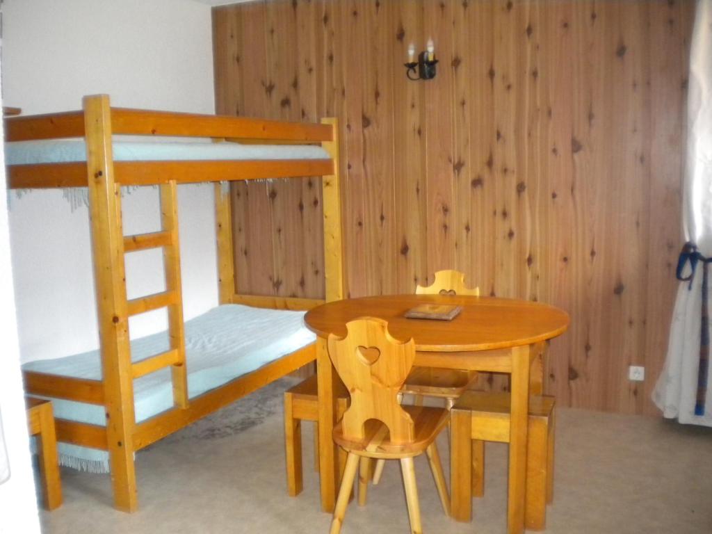 a wooden bunk bed with a table and a chair at Mercier in Lanslevillard
