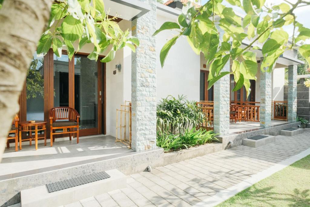 a home with a porch with a table and chairs at Nyuh Gading by The Lavana in Uluwatu