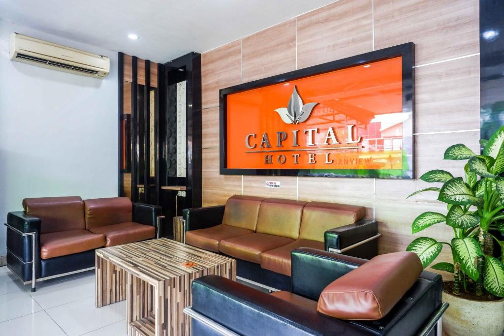 Urbanview Hotel Capital Makassar في Pampang: غرفة انتظار بأثاث جلدي وطاولة قهوة