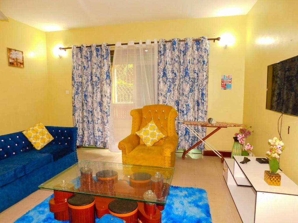ein Wohnzimmer mit einem blauen Sofa und einem Glastisch in der Unterkunft Luxurious 3 bedroom Furnished Apartment R1 in Shanzu