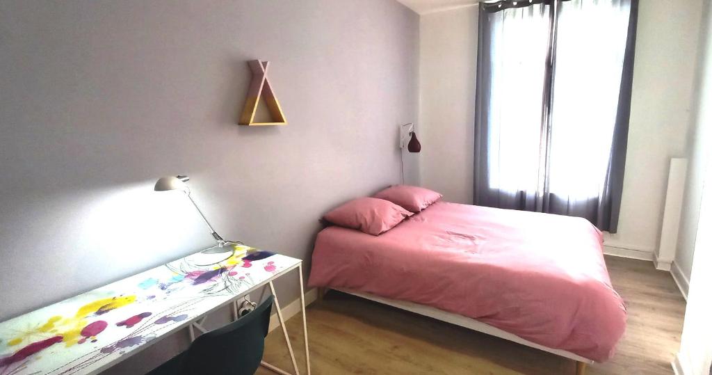 a small bedroom with a pink bed and a desk at Histoire de Loire - ANJOU sdb partagée in Saumur