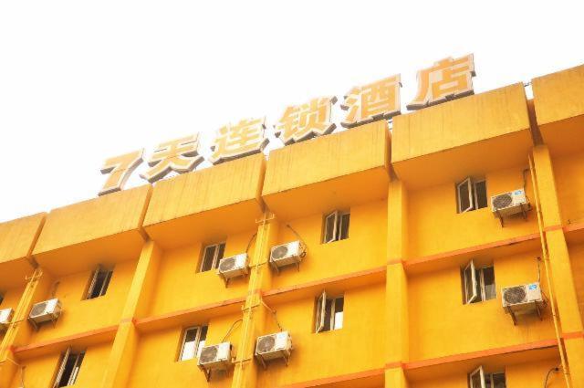 成都7天连锁酒店成都正府街文殊坊店的一座大型黄色建筑,上面配有空调
